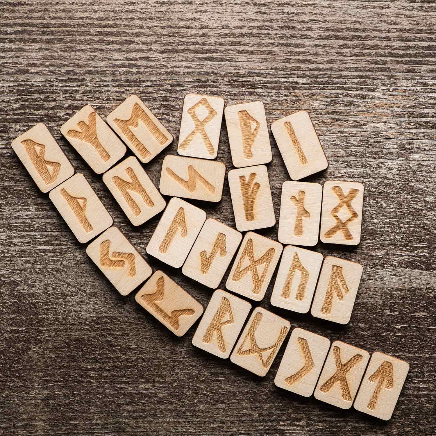 Yakma (pirografi) tekniği kullanılarak Elder Futhark sembollerinin işlendiği, rustik tasarımlı el yapımı doğal ahşap rune kehanet seti.