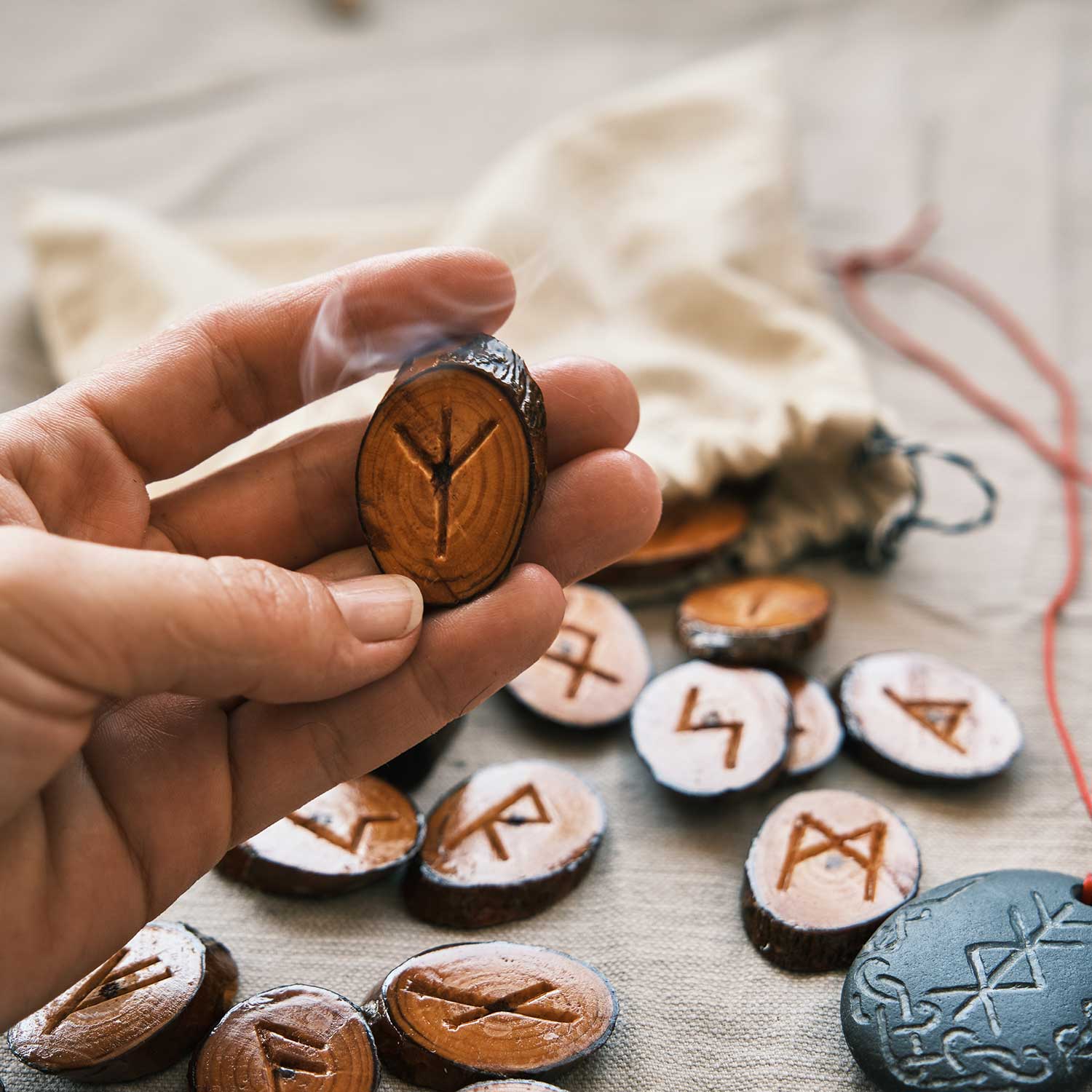 Bir kişinin avuçlarında sunduğu, üzerleri ahşap Elder Futhark sembolleri